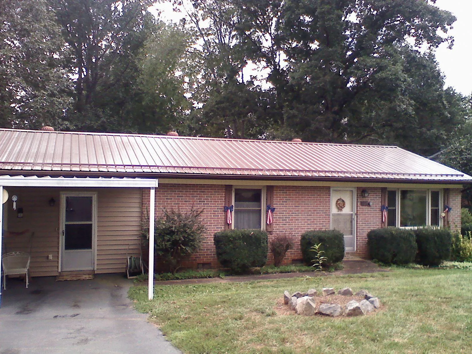 Bronze metal roof and carport on a brick ranch home — Roof Repair work by our crew in Crestwood